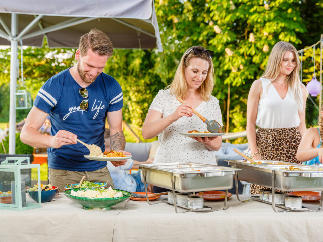 Mensen scheppen hun buffet op uit de warmhoudschalen