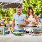 Twee personen scheppen hun bord vol met een heerlijk buffet